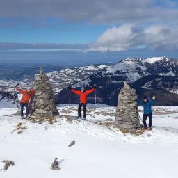Zwei riesengrosse Steinmänner und drei Schneeschuhläufer auf der Schneeschuhroute im Frümseltal.