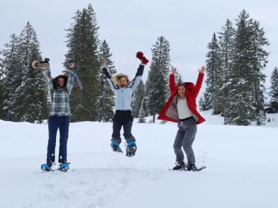 Schneeschuhläuferinnen haben Spass und machen einen Freudensprung vor der Kulisse der Churfirsten.