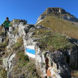 Wanderer im Abstieg vom Churfirst Zuestoll über den weiss-blau-weiss markierten Alpinwanderweg.